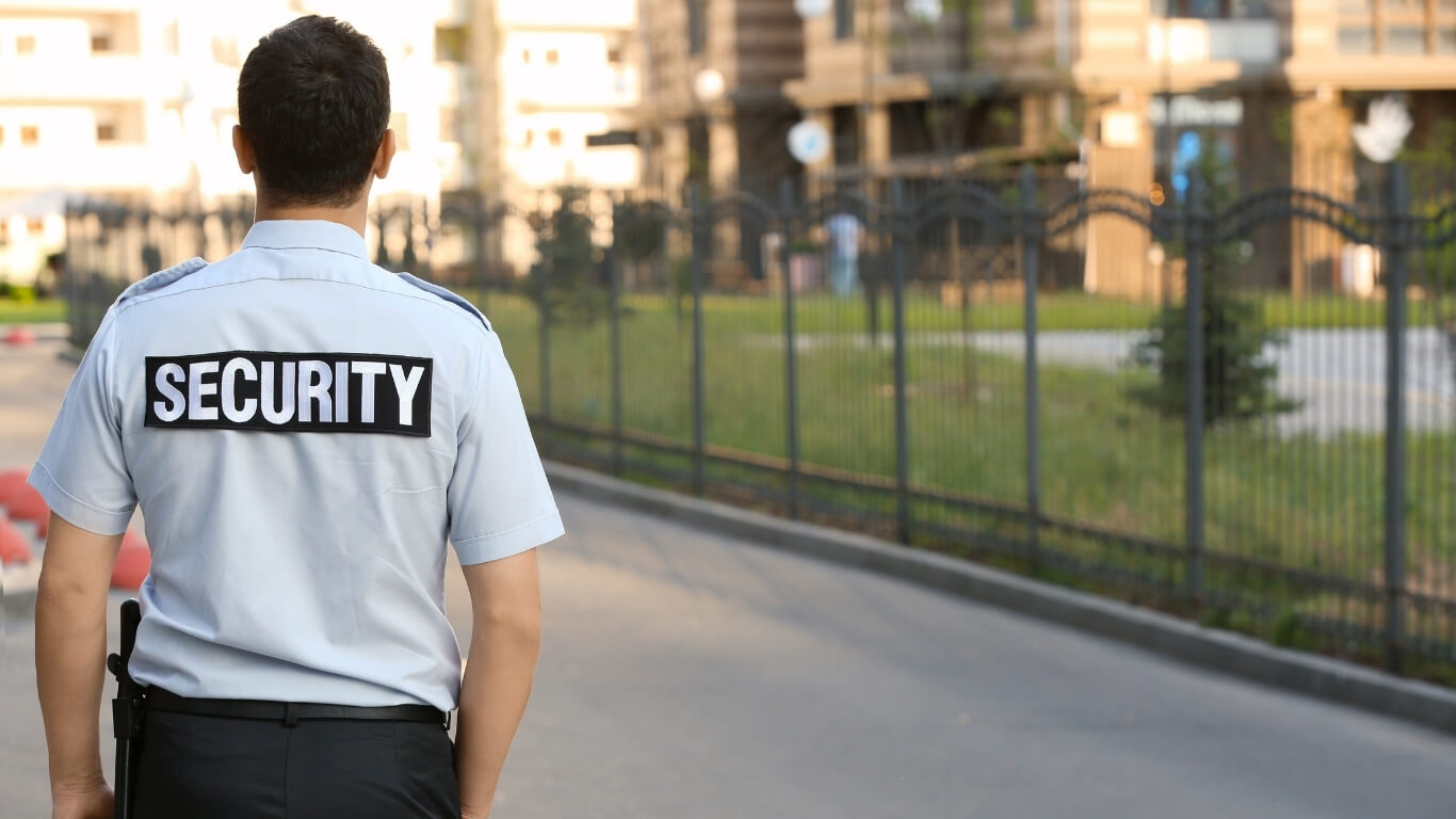 Security Mitarbeiter vor Wohnhausanlage